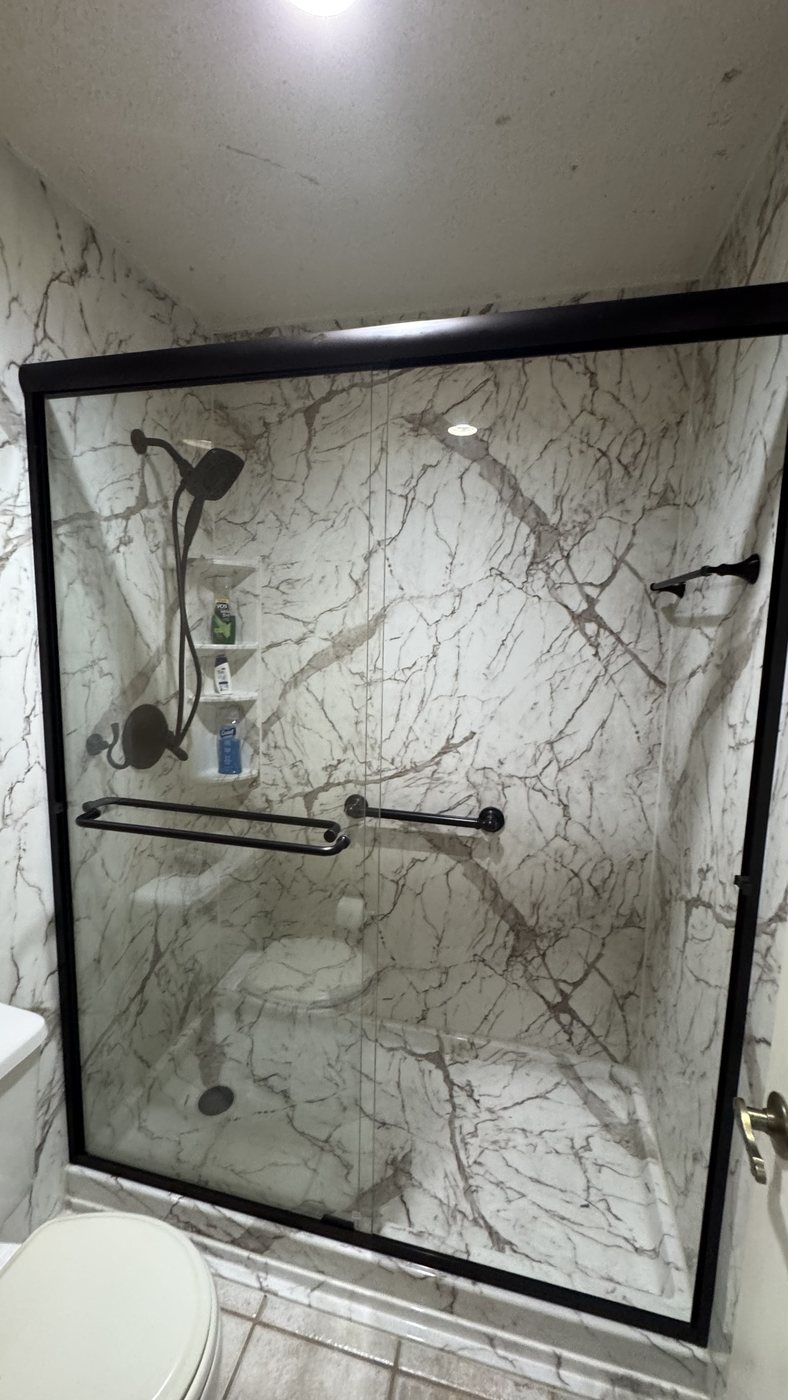 Marble-look PVC shower with black-framed glass doors