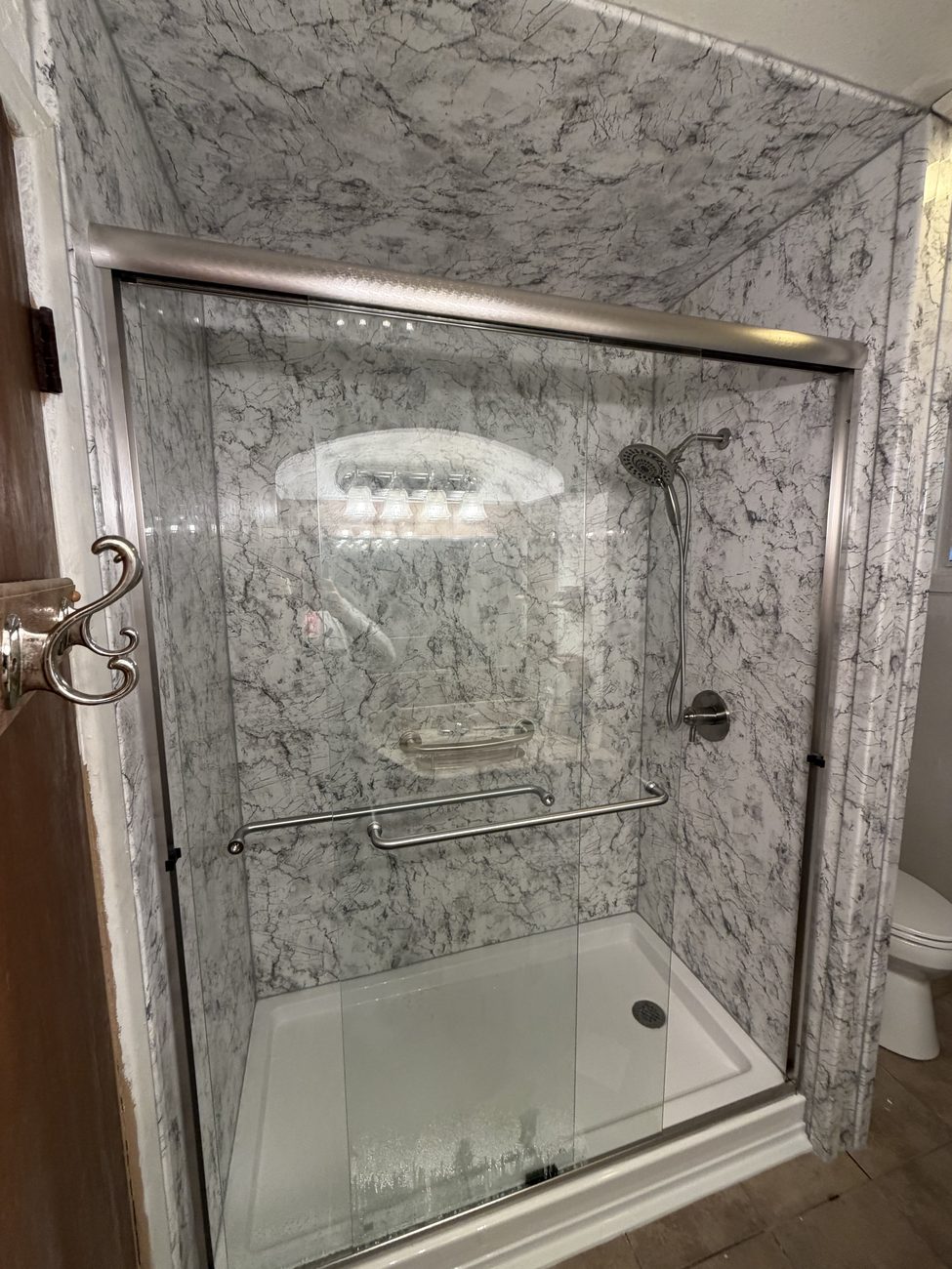 Marble-look corner shower with chrome fixtures