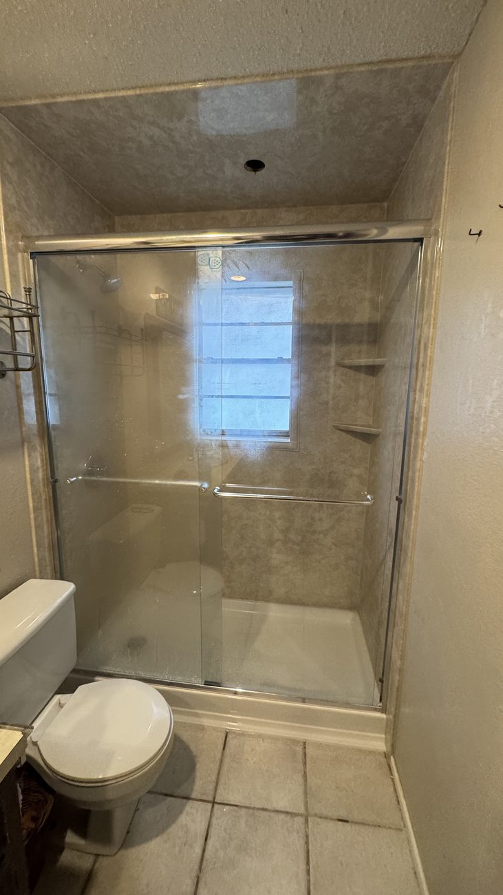Travertine-look shower with sliding glass doors